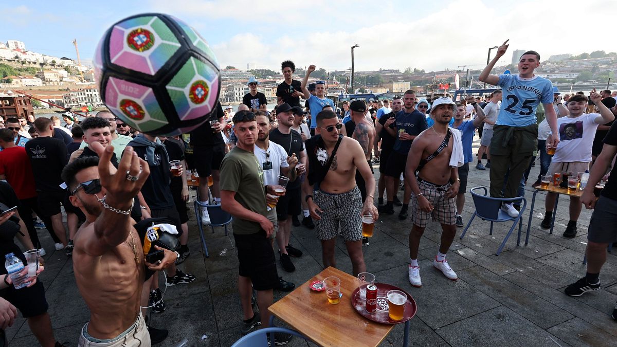 Manchester City supporters drink and chant by the Douro river bank in Porto, Portugal, Friday, May 28, 2021. 