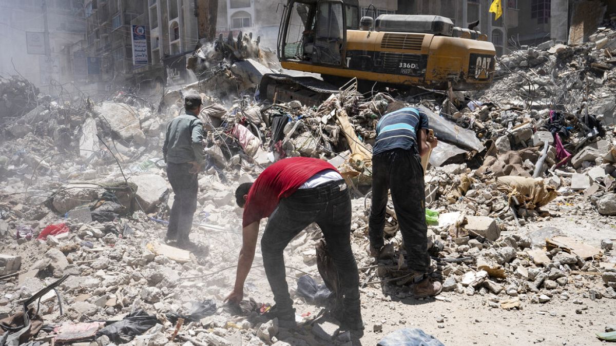 Heavy machinery sifts through the rubble of a destroyed building in Gaza for valuables on Thursday, May 27