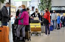 Travellers stand in an airport in the Netherlands Travellers stand in an airport in the Netherlands