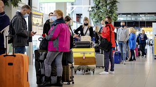 Travellers stand in an airport in the Netherlands