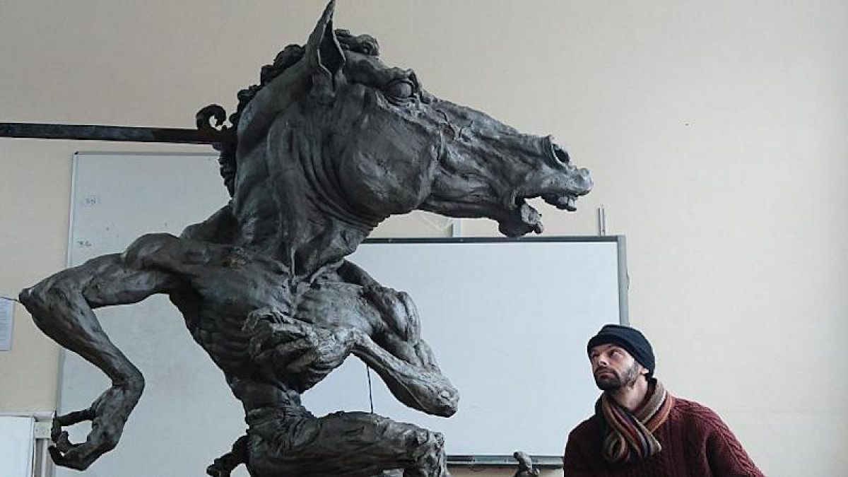 lo scultore Aidan Harte con la sua opera