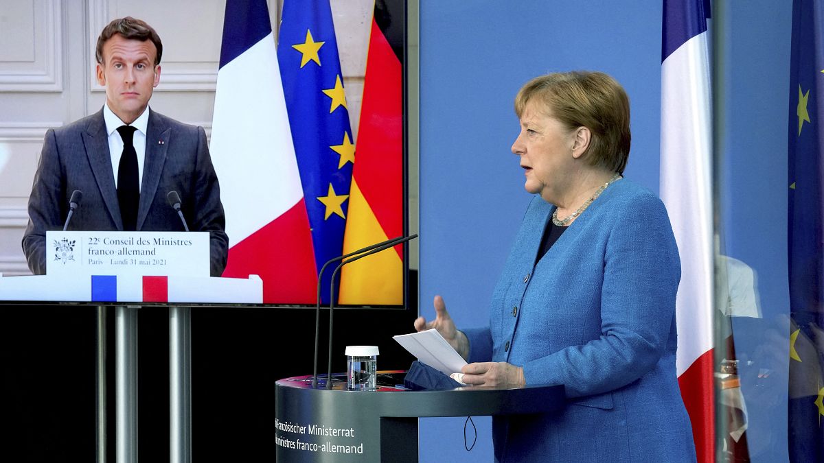 الرئيس الفرنسي إيمانويل ماكرون يظهر على شاشة فيديو خلال مؤتمر صحفي مشترك مع المستشارة الألمانية أنغيلا ميركل.