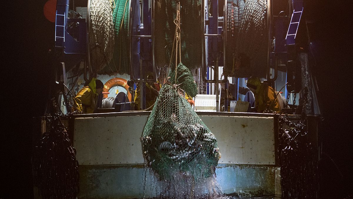 Pescadores recogen sus redes durante un jornada de pesca de arrastre en las aguas del golfo de Vizcaya, frente a las costas de Francia