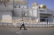 Damasco 2011: un agente pattuglia l'ingresso dell'ambasciata statunitense, danneggiata da manifestanti pro-governativi