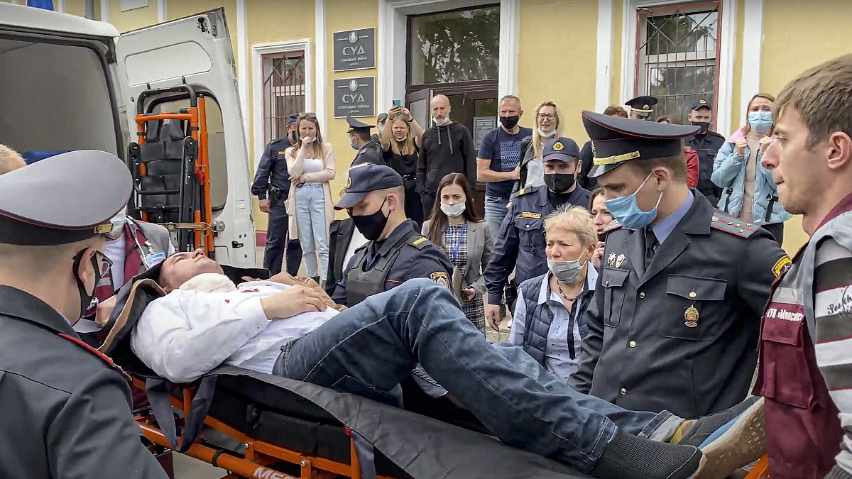 Police officers and paramedics carry Stsiapan Latypau, a Belarusian activist who attempted to kill himself during a court hearing in Minsk, Belarus, Tuesday, June 1, 2021