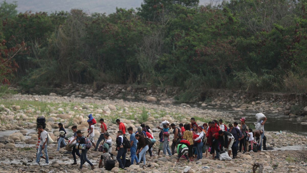 Ülkelerindeki sosyal ve ekonomik krizden kaçan Venezuelalılar, Tachira Nehri'ni kullanarak Kolombiya'ya kaçarken (27 Şubat 2019)