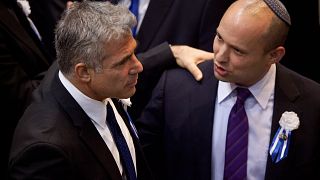 FILE: Yair Lapid, left, and Naftali Bennett, talk during the opening session of Israel's newly talk during the opening session of Israel's newly elected parliament, 2013