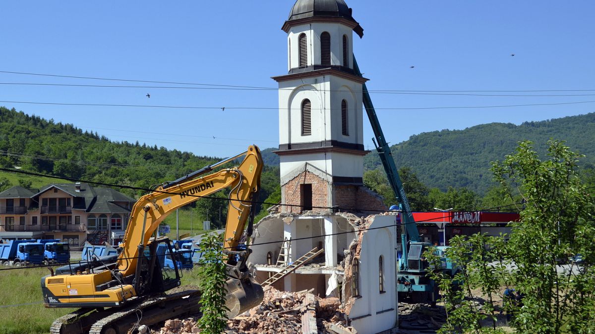 Una mujer bosnia vuelve a casa tras la demolición de una iglesia serbia que ocupaba su patio trasero