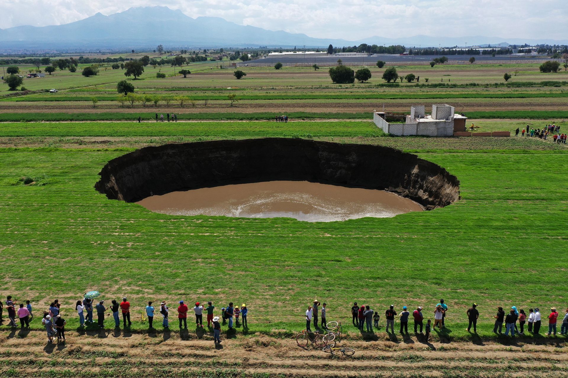 Aerial view of a sinkhole that was found by farmers in a field of crops in Santa Maria Zacatepec, state of Puebla, Mexico. May 30, 2021