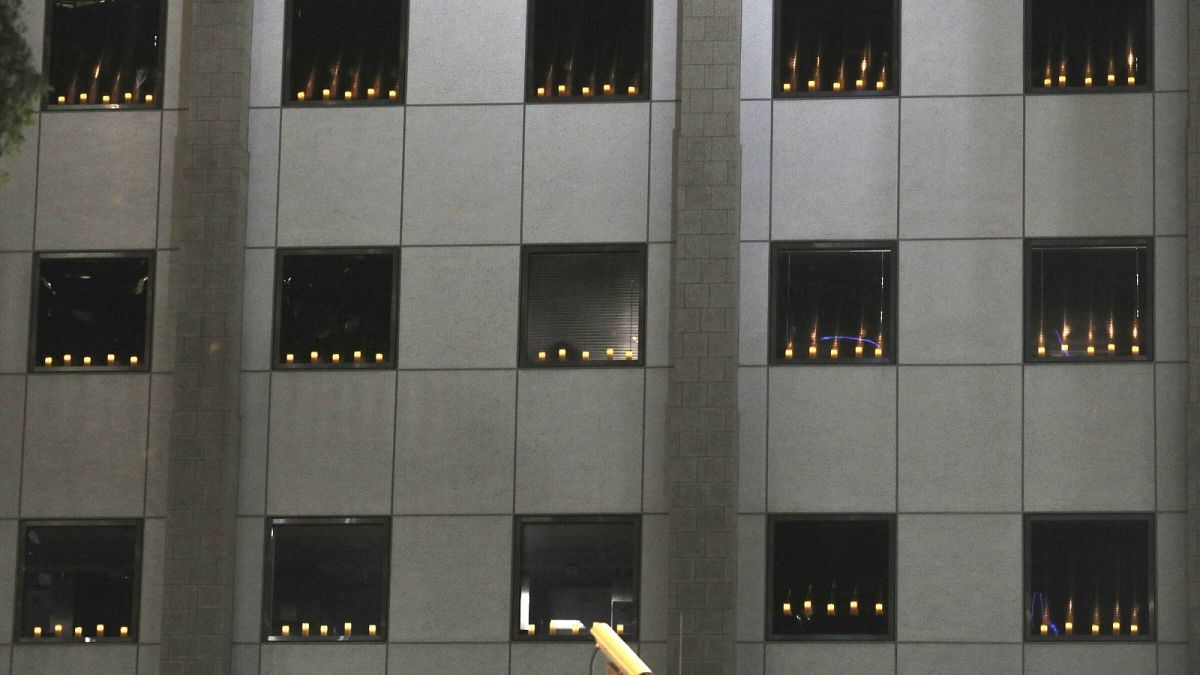 شمع‌های روشن پشت پنجره ساختمان کنسولگری آمریکا در هنگ‌کنگ به یاد قربانیان تیان‌آ‌ن‌من
