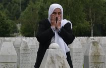 Munira Subasic who lost her son and the husband in Srebrenica massacre prays at the memorial cemetery in Potocari near Srebrenica, Bosnia, Friday, May 28, 2021.