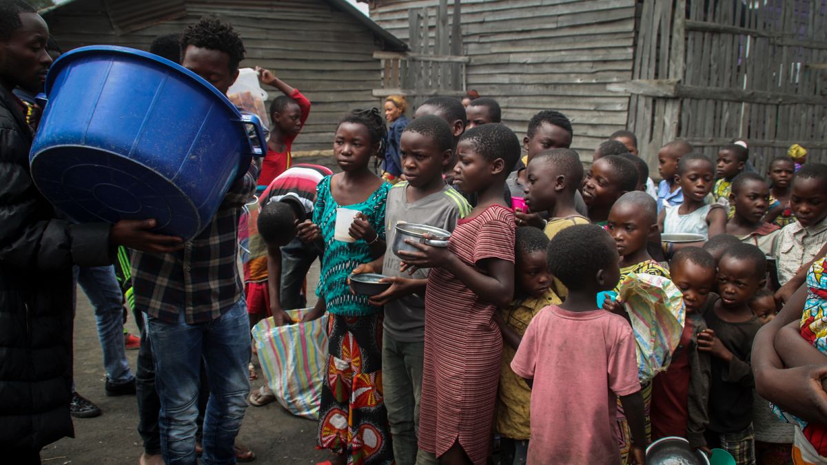 أطفال نازحون من ثوران بركان نيراغونغو يتلقون الطعام من متطوعين في بلدة ساكي شمال غرب غوما في شرق الكونغو الديمقراطية.