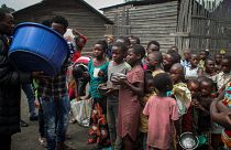 أطفال نازحون من ثوران بركان نيراغونغو يتلقون الطعام من متطوعين في بلدة ساكي شمال غرب غوما في شرق الكونغو الديمقراطية.