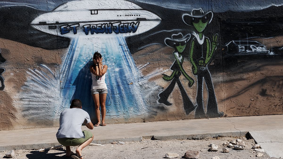 يلتقط الزوار صورًا أمام لوحة جدارية تصور سفينة فضاء خارج مركز فراش جارك في هيكو نيفادا.
