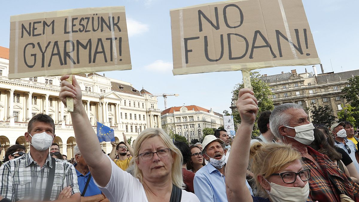 Los manifestantes sostienen pancartas en las que se lee en húngaro "no seremos una colonia", a la izquierda, y "no Fudan" en Budapest, Hungría, el 5 de junio de 2021.