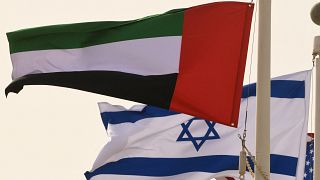 أعلام الإمارات وإسرائيل والولايات المتحدة تتأرجح في مطار أبو ظبي عند وصول أول رحلة تجارية من إسرائيل إلى الإمارات في 31 أغسطس، 2020.
