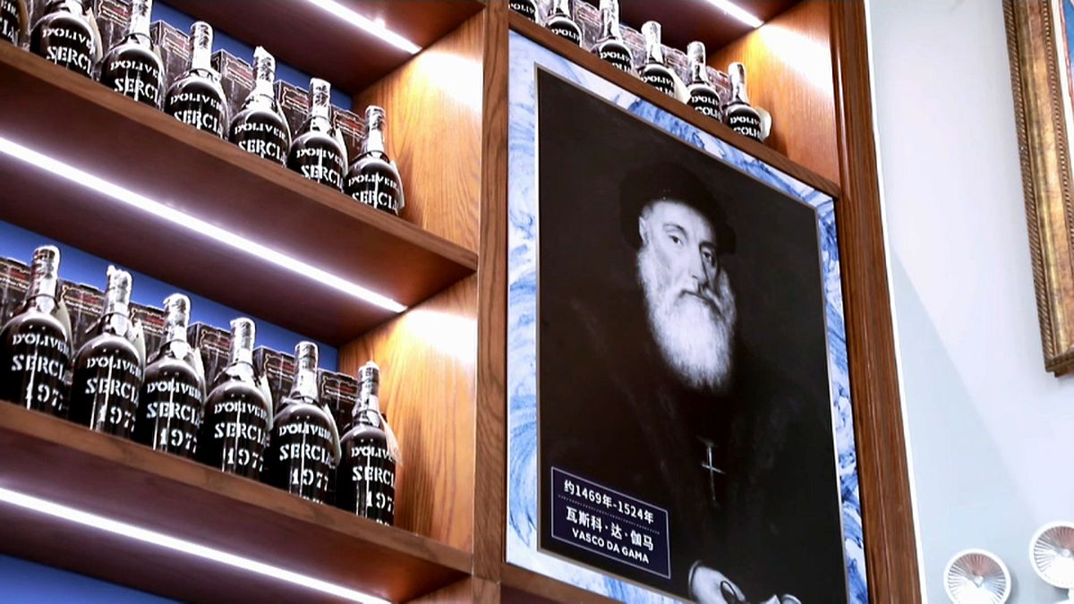 Retrato do navegador Vasco da Gama entre as garrafas exibidas na loja "Madeira Home"