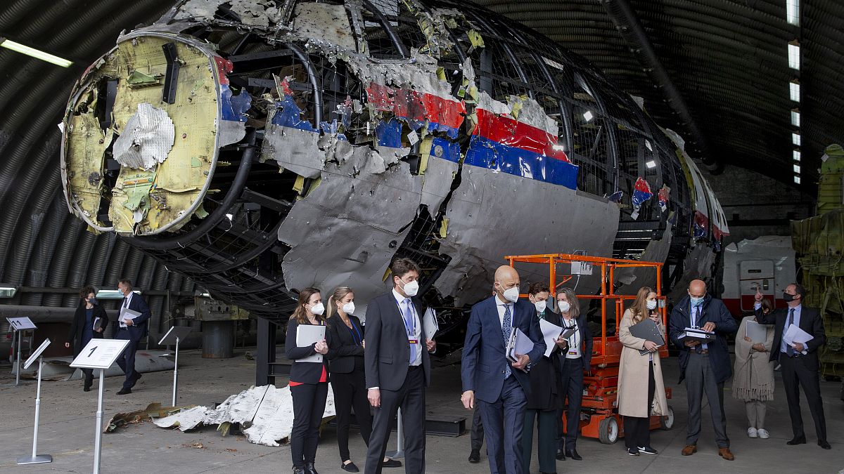 Judges and lawyers view the reconstructed wreckage of Malaysia Airlines Flight MH17, at the Gilze-Rijen military Airbase, southern Netherlands, Wednesday, May 26, 2021.