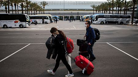 Passengers wearing face masks arrive at Palma de Mallorca Airport on the Spanish Balearic Island of Mallorca, Spain, Saturday, March 27, 2021.