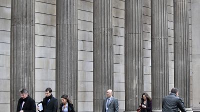 People walk past the Bank of England in the City of London's financial district People walk past the Bank of England in the City of London's financial district