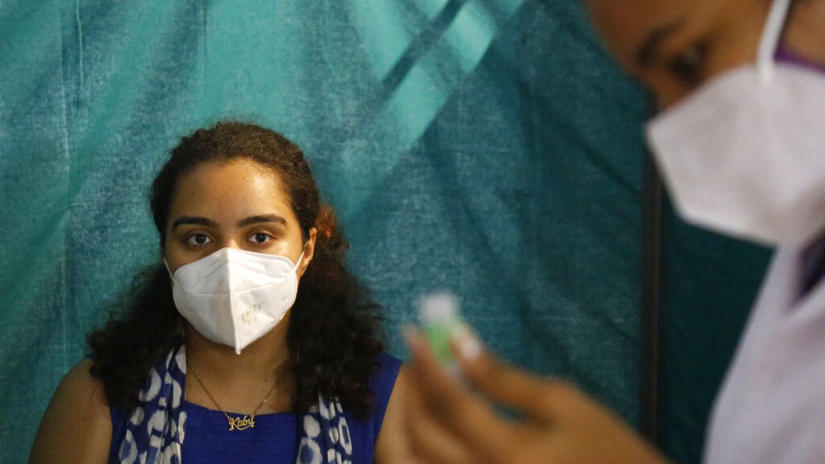 A woman waits to receive a dose of Covishield, the Oxford-AstraZeneca vaccine for COVID-19, in Ahmedabad, India, Saturday, June 5, 2021