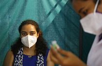 A woman waits to receive a dose of Covishield, the Oxford-AstraZeneca vaccine for COVID-19, in Ahmedabad, India, Saturday, June 5, 2021