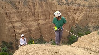 Charlotte Prud'homme (pictured left) abseiling to collect soil samples. 