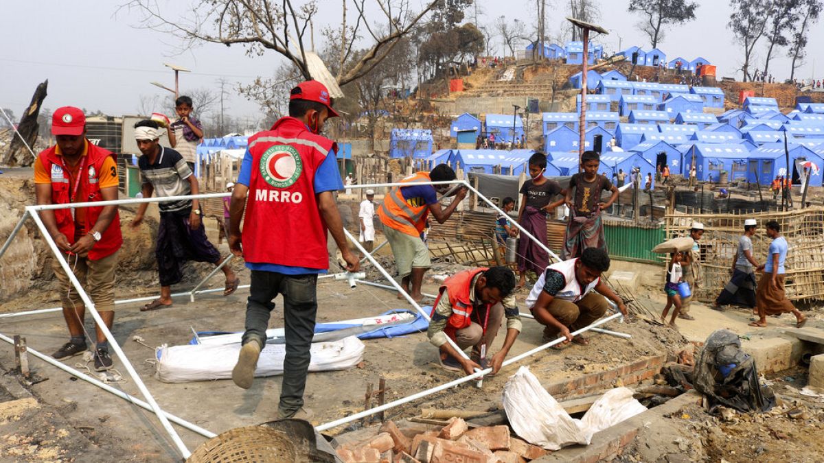 Volunteers help rebuild after a huge fire at a refugee camp for Rohingya Muslims in March: one of the locations set to be affected by the cuts
