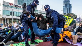 Police remove environmental activists of Extinction Rebellion group (XR) as they block one of the main streets in the city centre to draw attention to the climate crisis.