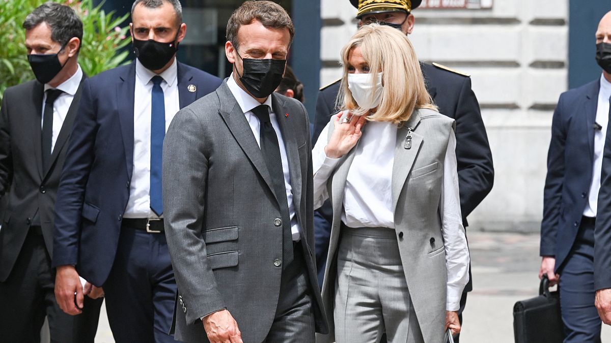 French President Emmanuel Macron (C) walks next to his wife Brigitte Macron before a lunch in Valence, on June 8, 2021,
