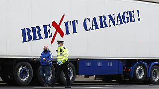 Jan, 18, 2021, a policeman escorts the driver of a shellfish export truck as he is stopped for an unnecessary journey in London.