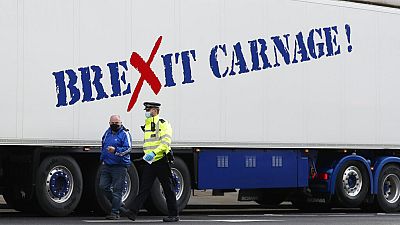 Jan, 18, 2021, a policeman escorts the driver of a shellfish export truck as he is stopped for an unnecessary journey in London.