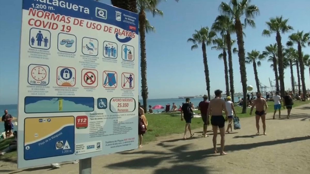 Ein Strand in Málaga mit einem Hinweisschild für die Corona-Regeln