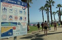Ein Strand in Málaga mit einem Hinweisschild für die Corona-Regeln