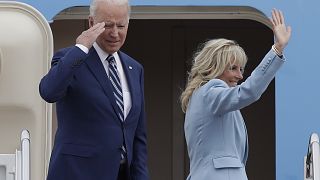 President Joe Biden salutes as first lady Jill Biden waves from the stairs of Air Force One