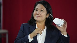 La candidata derechista Keiko Fujimori se quita la mascarilla en una rueda de prensa