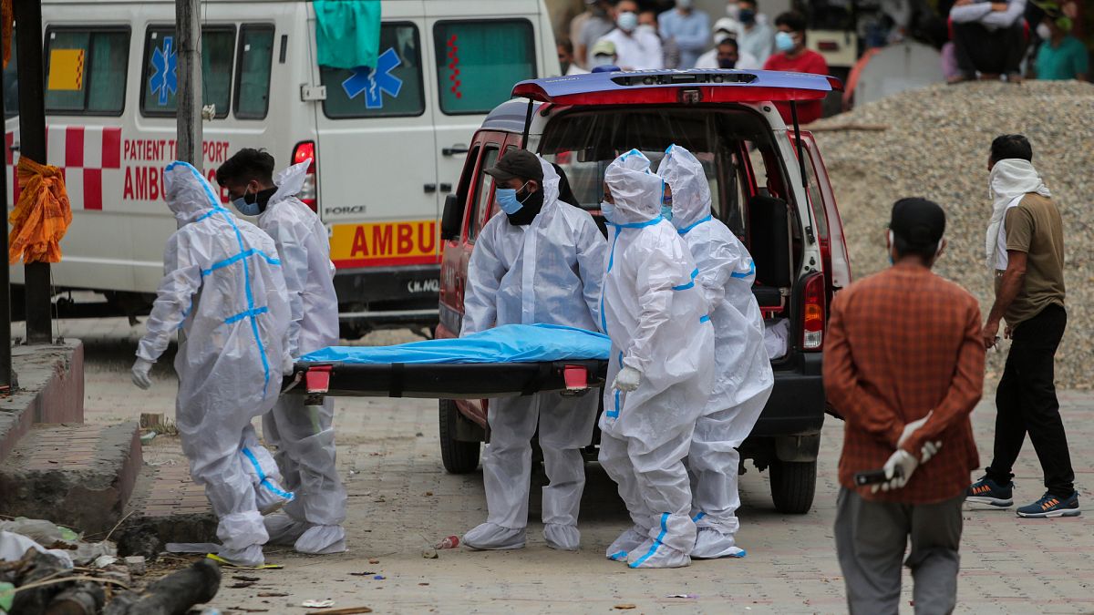 Hindistan'da Covid-19 nedeniyle hayatını kaybeden bir kişinin bedeni yakılmak üzere krematoryuma götürülürken