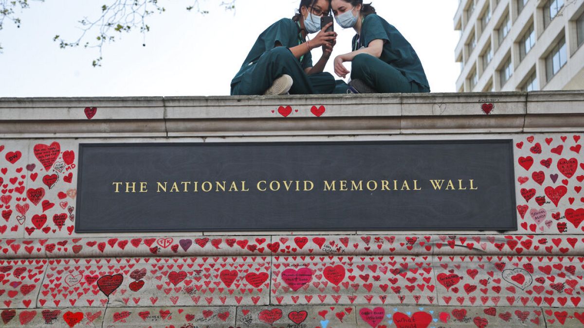 Londra, giugno 2021: infermiere dell'ospedale St Thomas riposano sul muro del memoriale nazionale per le vittime di Covid