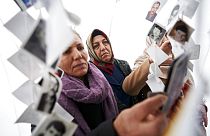 Women look at images of victims inside a traveling monument called 'Prijedor 92' outside the Yugoslav War Crimes Tribunal, ICTY