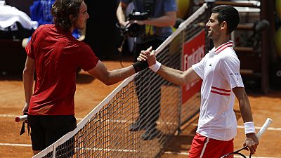 Serbia's Novak Djokovic greets Greece's Stefanos Tsitsipas, left
