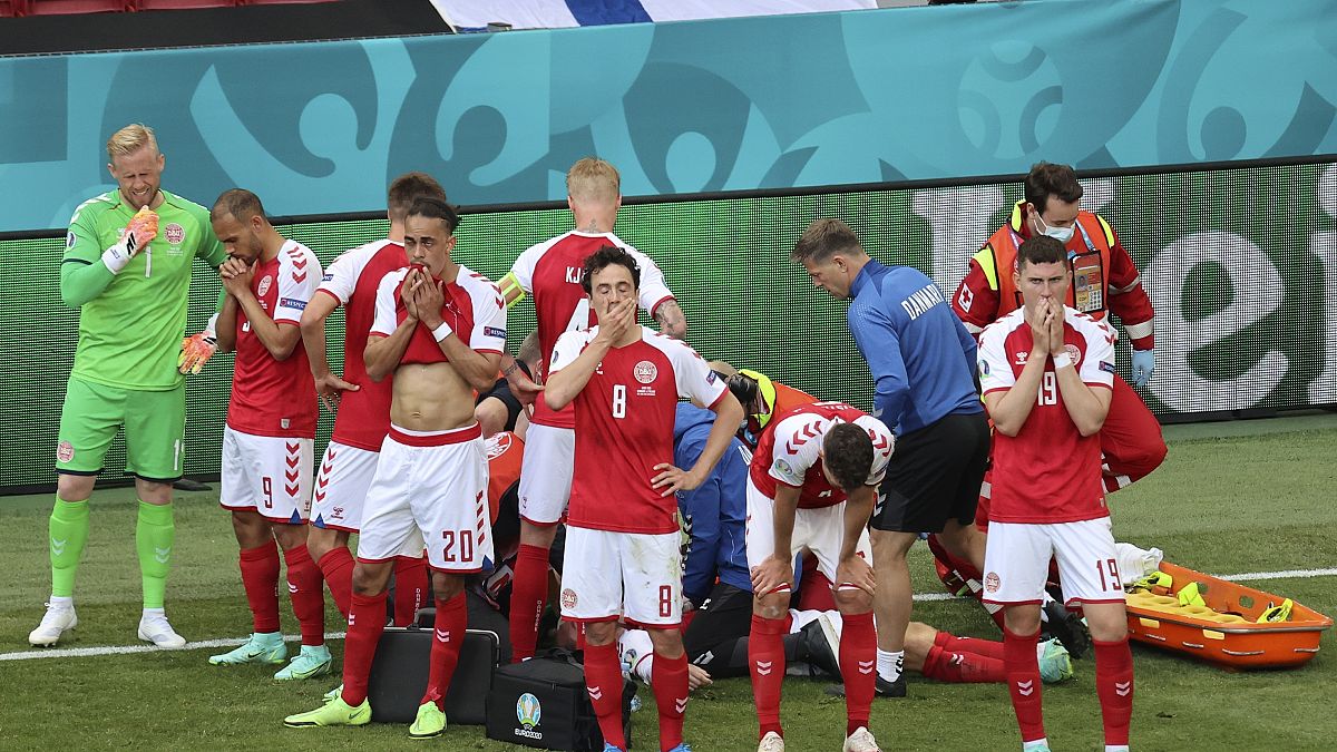 Denmark's players react as their teammate Christian Eriksen lays injured on the ground during the Euro 2020 soccer championship group B match between Denmark and Finland,