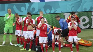 Denmark's players react as their teammate Christian Eriksen lays injured on the ground during the Euro 2020 soccer championship group B match between Denmark and Finland,