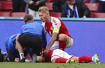 Eriksen es atendido por sus compañeros en el terreno de juego, después de desmayarse