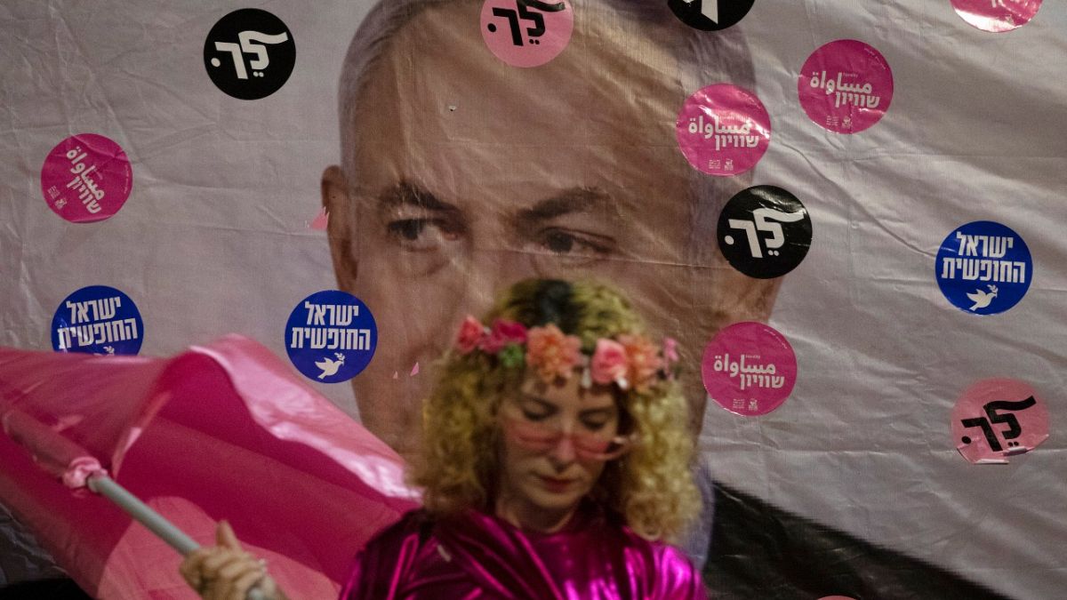 An Israeli protester wears pink during a demonstration against Israeli Prime Minister Benjamin Netanyahu outside his official residence in Jerusalem, Saturday, June 12, 2021. 