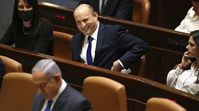 Le nouveau Premier ministre israélien assiste à une session de la Knesset, assis derrière Benjamin Netanyahou, le 13 juin 2021