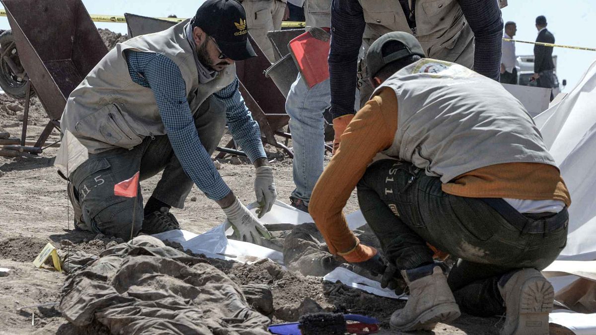 براء الطب الشرعي يفحصون رفات بشرية بعد اكتشافهم مقبرة جماعية في قرية بادوش شمال العراق تعود لضحايا مذبحة سجن بادوش عام 2014 التي ارتكبها تنظيم الدولة الإسلامية، 13 يونيو 2021