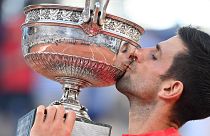 A világelső szerb Novak Djokovic ünnepel a bajnoki trófeával a párizsi Roland Garros Stadionban