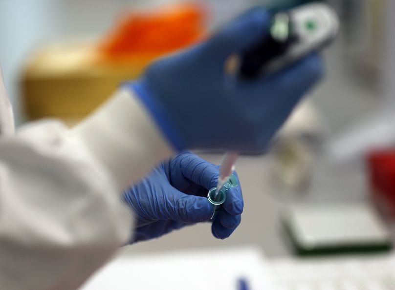 Un asistente de laboratorio utiliza una pipeta para preparar el ARN Coronavirus para la secuenciación en el Instituto Wellcome Sanger en Cambridge, 2021.