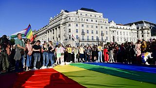 People unfurl a rainbow flag during an LGBT rights demonstration in front of the Hungarian Parliament building in Budapest, Hungary on June. 14, 2021.