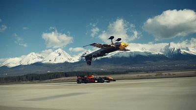 Red Bull F1 car driving very close to inverted race plane
